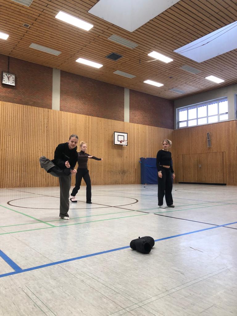 Tänzerinnen in der Turnhalle machen ein Warmup für die anstehende Formation