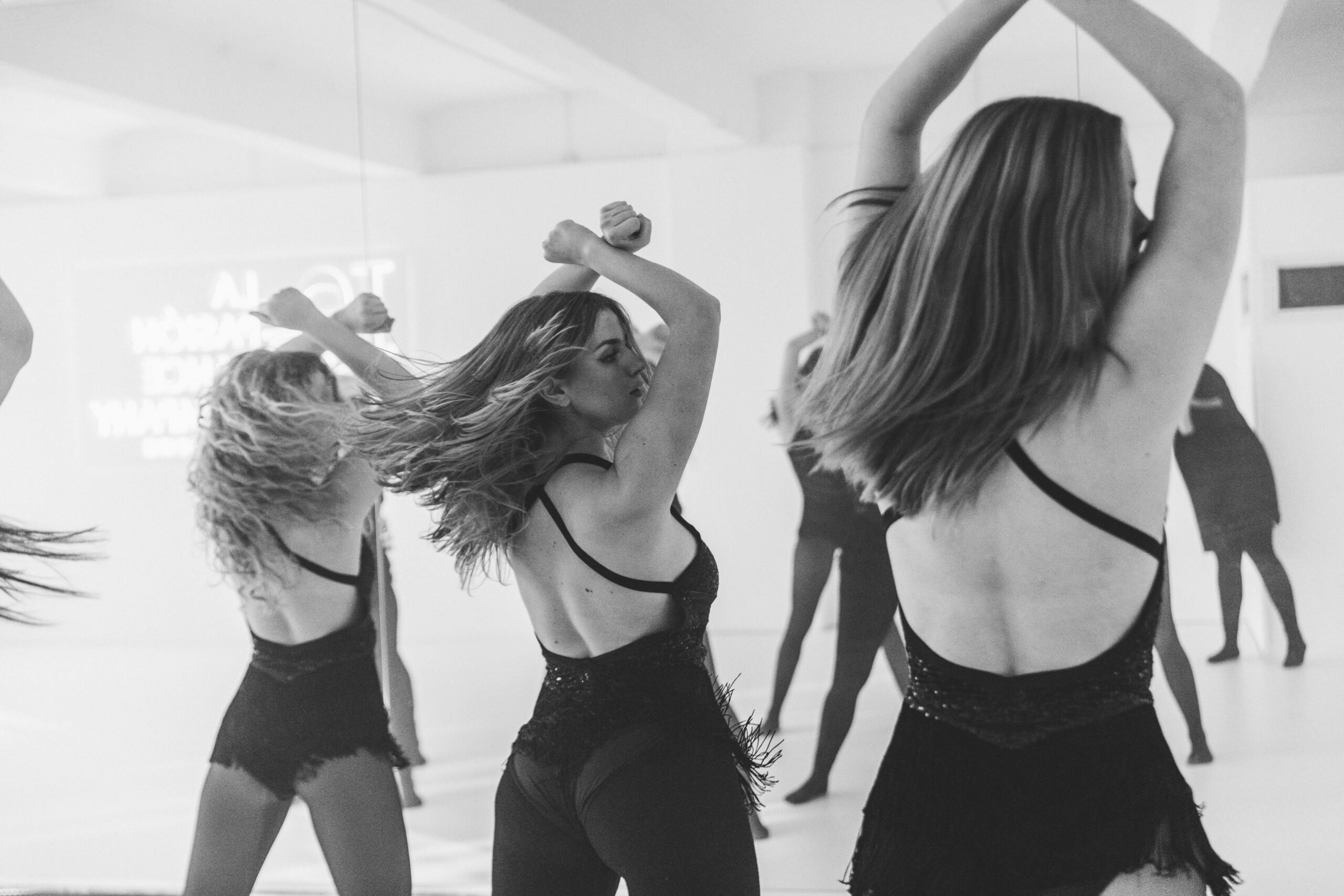 Mädchen im Studio machen dynamische Bewegungen mit Jazz Kostümen